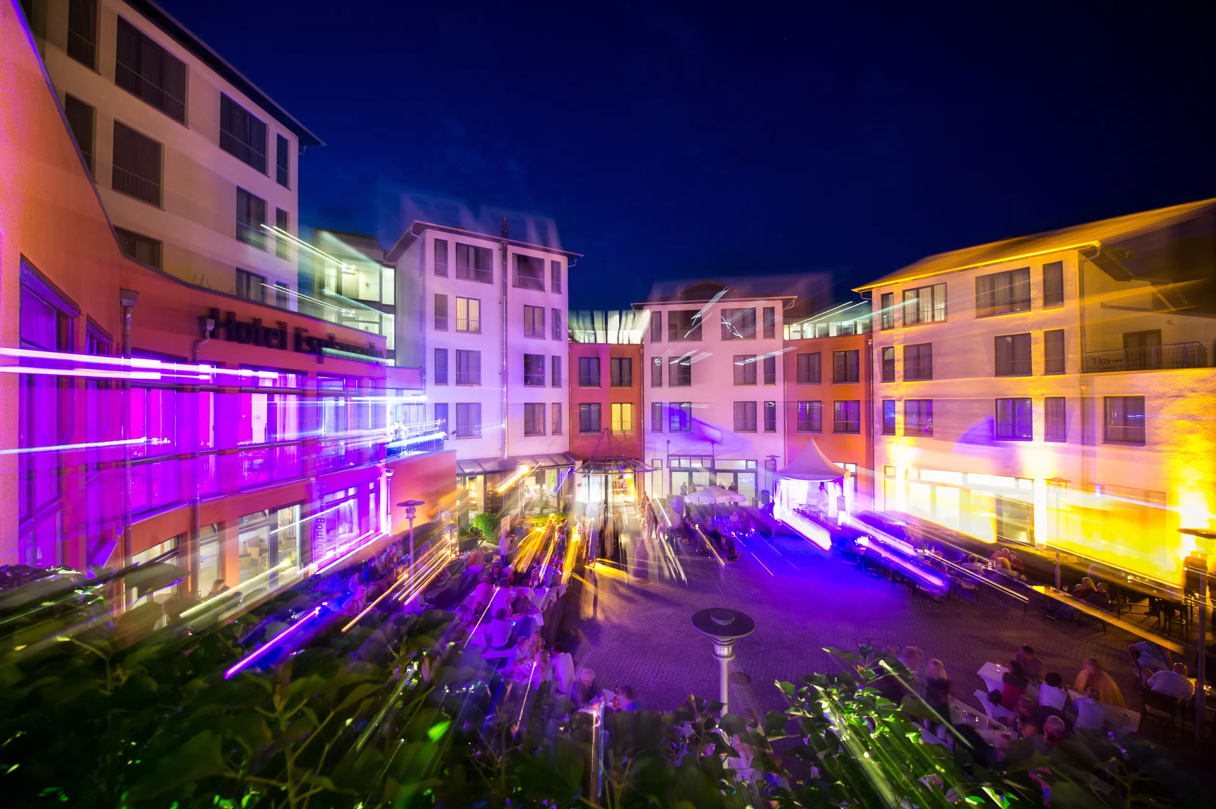 beleuchtetes Hotelforum bei Dunkelheit mit bunten Lichteffekten