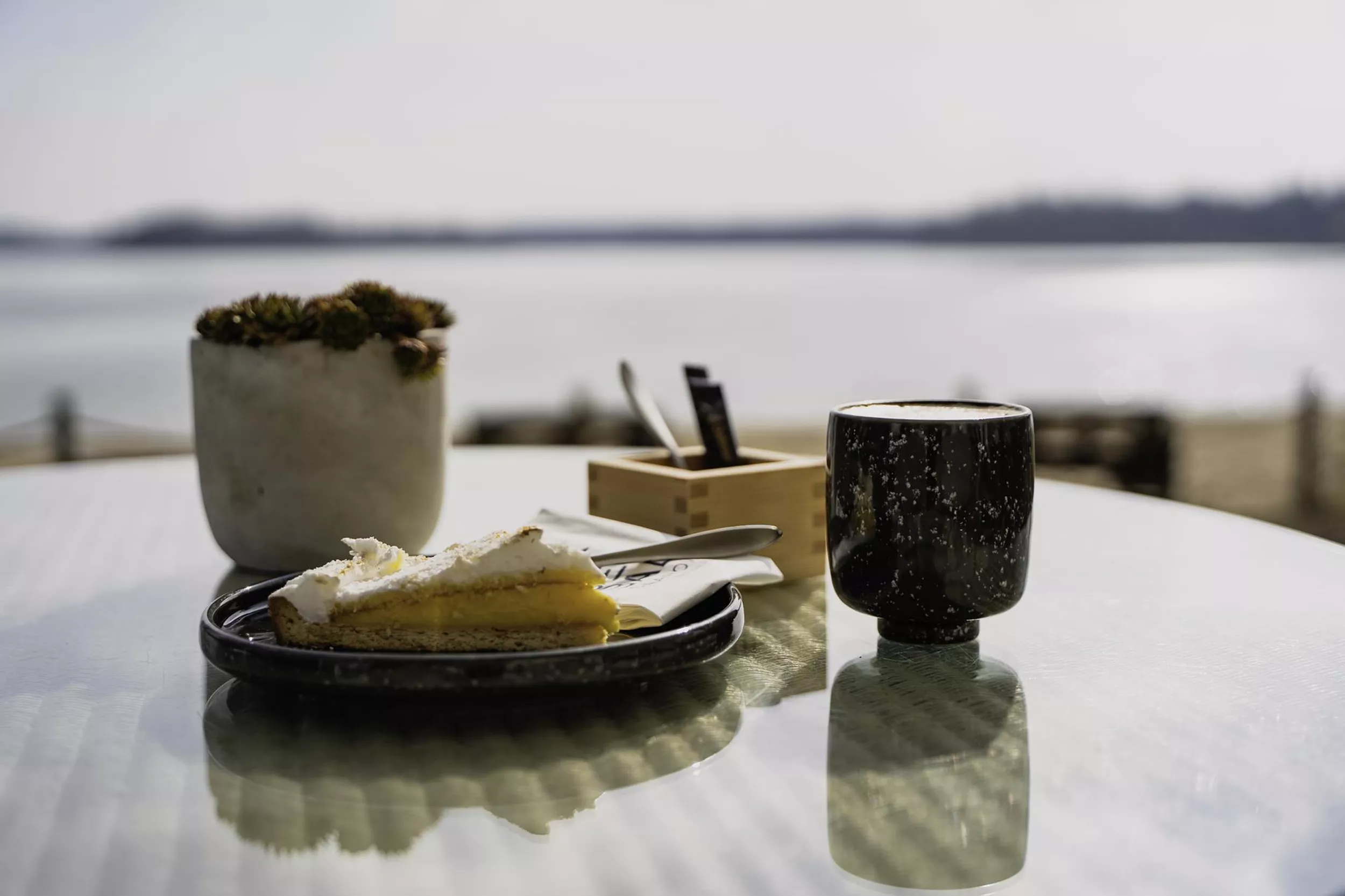 Kaffee  und Kuchen auf Glastisch vor See